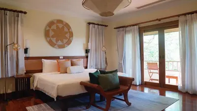 a bedroom with a bed with a chair and a window at \u666e\u5409\u9ad8\u7aef\u5eb7\u517b\u6cf3\u6c60\u522b\u5885 in Layan Beach