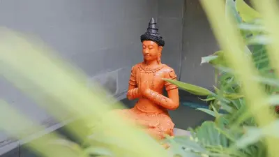 a statue of a monk with a hat on at \u666e\u5409\u9ad8\u7aef\u5eb7\u517b\u6cf3\u6c60\u522b\u5885 in Layan Beach