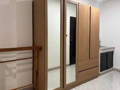 a room with a wooden closet with a mirror at M2 Room For Rent in Patong Beach