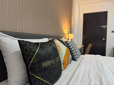 a bed with several pillows on top of it at M2 Room For Rent in Patong Beach