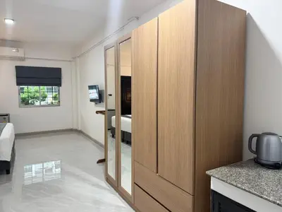a large wooden cabinet in a room with a bedroom at M2 Room For Rent in Patong Beach