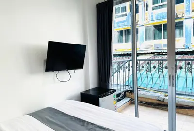 a bedroom with a bed and a flat screen tv at M2 Room For Rent in Patong Beach