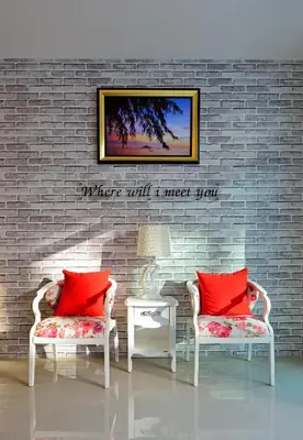 a living room with two chairs and a brick wall at Kiss Hometel in Ao Nang Beach