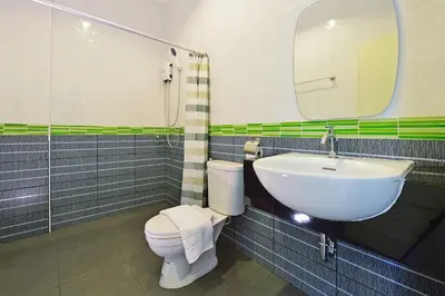 a bathroom with a sink and a toilet and a mirror at Kiss Hometel in Ao Nang Beach