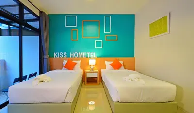 two beds in a room with a green wall at Kiss Hometel in Ao Nang Beach