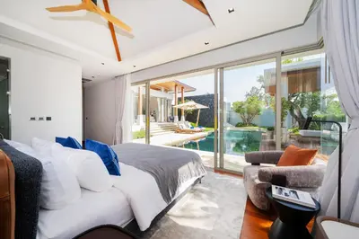 a bedroom with a bed and a large window at Luxury Royale Bangtao Pool Villa with maid in Thalang
