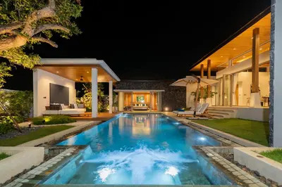 a pool in the backyard of a house at night at Luxury Royale Bangtao Pool Villa with maid in Thalang