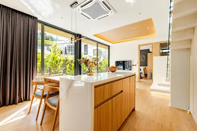 an open kitchen and dining room with a large window at Aileen Naithon Hills - Tropical Haven Retreat in Nai Thon Beach