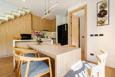 a kitchen and dining room with a wooden table and chairs at Aileen Naithon Hills - Tropical Haven Retreat in Nai Thon Beach
