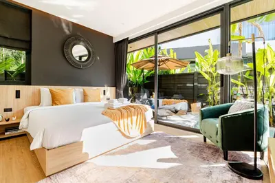 a bedroom with a white bed and a green chair at Aileen Naithon Hills - Tropical Haven Retreat in Nai Thon Beach