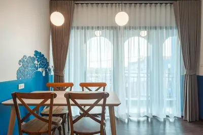 a dining room with a table and four chairs at Blu Monkey Boutique Naiharn - Serviced Apartments 1 Bedroom in Rawai Beach