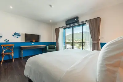 a bedroom with a bed and a desk and a window at Blu Monkey Boutique Naiharn - Serviced Apartments 1 Bedroom in Rawai Beach