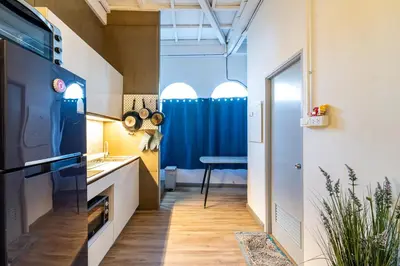 a small kitchen with a blue curtain and a table at Queen On Street 2009 in Ban Lo Long