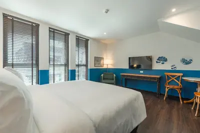a bedroom with a bed and a desk and a tv at Blu Monkey Boutique Naiharn - Serviced Apartments 2 Bedrooms in Rawai Beach