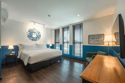 a bedroom with a bed and a table and a couch at Blu Monkey Boutique Naiharn - Serviced Apartments 2 Bedrooms in Rawai Beach