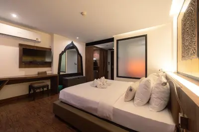 a bedroom with a bed and a desk and a television at The Beach Residence Kata in Kata Beach
