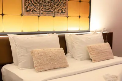 a bed with white pillows and a head board at The Beach Residence Kata in Kata Beach