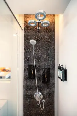a shower in a bathroom with a tile wall at The Beach Residence Kata in Kata Beach