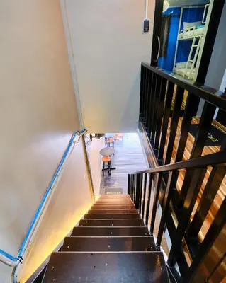a staircase leading up to a room with a table and a chair at Friendz Hostel in Phi Phi Don