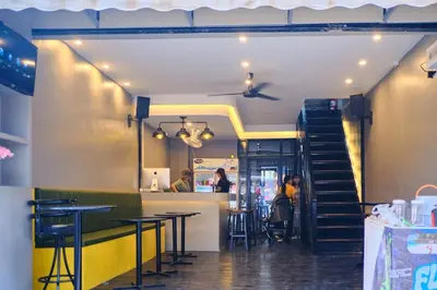 a restaurant with tables and a staircase in the background at Friendz Hostel in Phi Phi Don