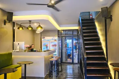 a restaurant with a staircase leading to a bar at Friendz Hostel in Phi Phi Don