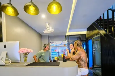 a group of people standing around a kitchen counter at Friendz Hostel in Phi Phi Don