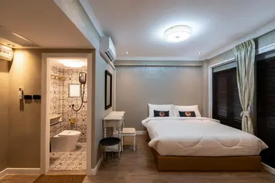 a bedroom with a large bed and a bathroom at RQ Timeless Phuket Old Town in Phuket Town