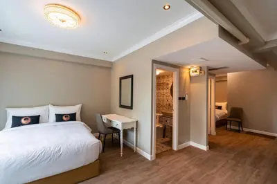 a bedroom with a bed and a table and a desk at RQ Timeless Phuket Old Town in Phuket Town