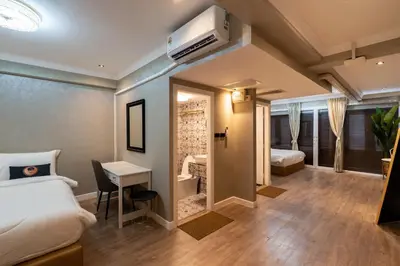 a hotel room with a bed and a desk and a bedroom at RQ Timeless Phuket Old Town in Phuket Town