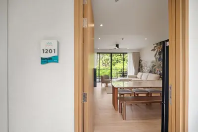 a open door to a living room with a table at Laguna Beach Residences Seashore by Banyan Living in Thalang