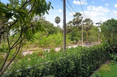 a bridge over a road with trees and bushes at Laguna Beach Residences Seashore by Banyan Living in Thalang