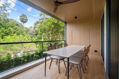 a dining room with a table and chairs and a large window at Laguna Beach Residences Seashore by Banyan Living in Thalang