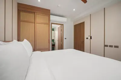 a bedroom with a white bed and a window at Laguna Beach Residences Seashore by Banyan Living in Thalang