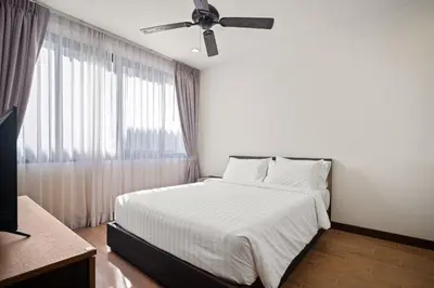 a bedroom with a bed and a ceiling fan at Laguna Parkside Residences by Banyan Living in Phuket Town