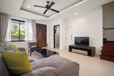 a living room with a couch and a flat screen tv at Laguna Parkside Residences by Banyan Living in Phuket Town