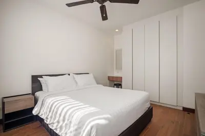 a bedroom with a white bed and a ceiling fan at Laguna Parkside Residences by Banyan Living in Phuket Town