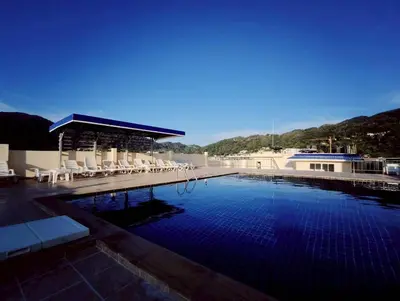 a large swimming pool with chairs and a building at 3-bedroom apartment, Patong, Palm Spring 602 in Patong Beach