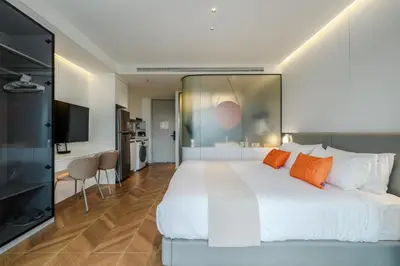 a bedroom with a large white bed with orange pillows at Elegant Beachside Retreat Modern Stay Pool Bar in Layan Beach