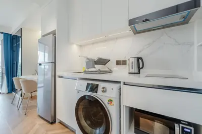 a washer and dryer in a kitchen with a counter at Elegant Beachside Retreat Modern Stay Pool Bar in Layan Beach