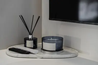 a table with two candles and a remote control at Elegant Beachside Retreat Modern Stay Pool Bar in Layan Beach