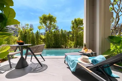 a patio with a table and chairs and a pool at Bangtao The Title Legendary by Phuket Sabay Rent C108 in Bang Tao Beach
