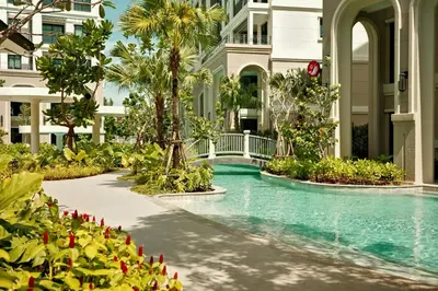 a swimming pool at a resort with palm trees and a building at Bangtao The Title Legendary by Phuket Sabay Rent C108 in Bang Tao Beach