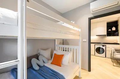 a bedroom with bunk beds and a living room at Bangtao The Title Legendary by Phuket Sabay Rent D204 in Bang Tao Beach
