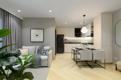 a living room and kitchen with a table and chairs at Bangtao The Title Legendary by Phuket Sabay Rent D204 in Bang Tao Beach