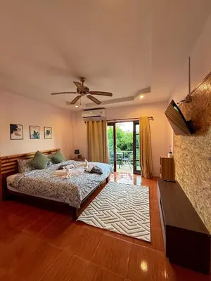 a bedroom with a bed and a ceiling fan at Sachi Home Bangtao -Private House Near Beach in Ban Thalat Choeng Thale