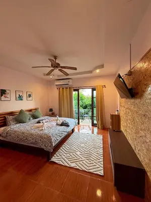 a bedroom with a bed and a ceiling fan at Sachi Home Bangtao -Private House Near Beach in Ban Thalat Choeng Thale