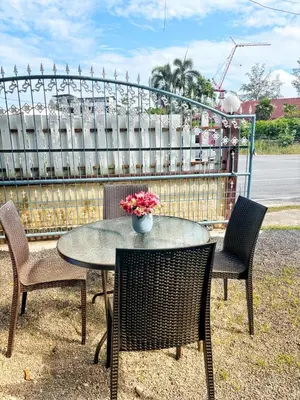 a table and chairs with a vase of flowers on it at Sachi Home Bangtao -Private House Near Beach in Ban Thalat Choeng Thale