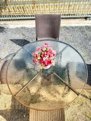 a glass table with a bouquet of flowers on it at Sachi Home Bangtao -Private House Near Beach in Ban Thalat Choeng Thale