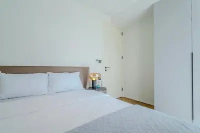 a bedroom with a large white bed and a lamp at Two Bedroom Sea View by Triple 8 Asia in Layan Beach