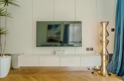 a living room with a television on a white wall at Two Bedroom Sea View by Triple 8 Asia in Layan Beach
